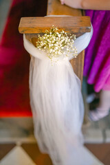 Floral wedding church pew decoration with roses, carnations and greenery