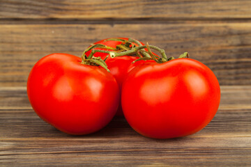 Red tomatoes on a wooden background.