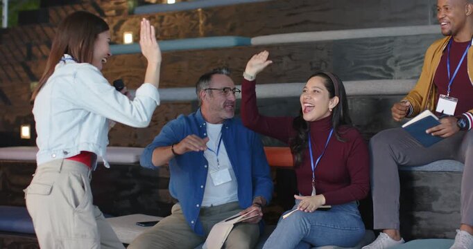 Microphone signal driving Diverse coworkers exchanging high-fives and cheering in meeting room