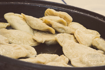 Fresh prepared fried dumplings on frying pan. Traditional polish food