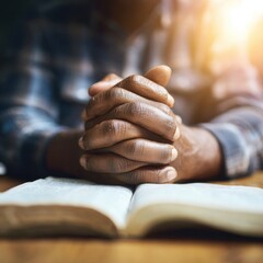 Obraz premium Hands clasped in prayer over an open book (6)