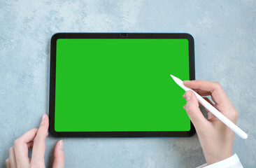 Female hand working with digital tablet on desk.