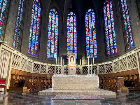 Presbytery and marble altar of Luxembourg Cathedral with stained glass windows in Gothic arches.