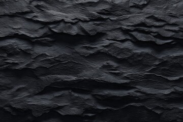 Dark, textured black rock surface with rugged layers and natural patterns, creating a dramatic and visually striking background