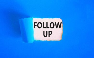 Follow up symbol. Concept word Follow up on beautiful white paper. Beautiful blue paper background. Business follow up concept. Copy space.