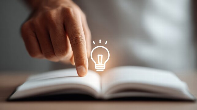 A hand points at a glowing lightbulb icon above an open book, symbolizing a bright idea.