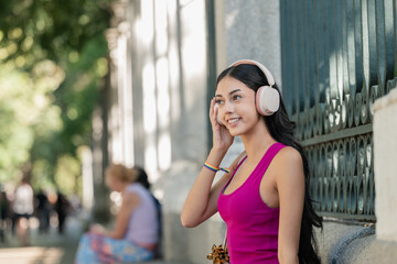 Fototapeta premium Young woman enjoying music wearing headphones with copy space