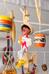 Traditional wooden puppet toy with typical mexican costume, background with typical mexican toys...