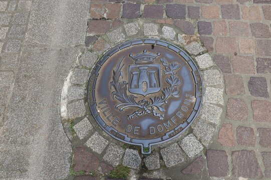 Armoiries de la ville sur une plaque d'&eacute;gout, village de Domfront en Poiraie, d&eacute;partement de l'Orne, France
