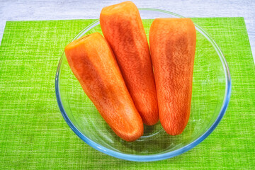 Washed and peeled carrots in a transparent plate.
