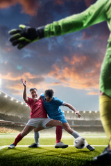 Obraz premium Tackling the ball. Professional soccer players in action. Soccer championship. Soccer arena full of fans. Sports concept. Sunset on stadium. Soccer. Vertical