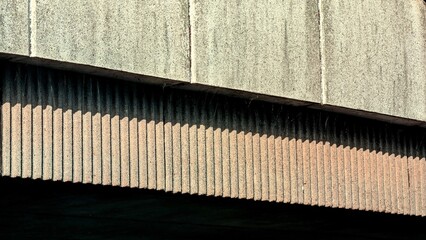 An abstract architectural detail of a brutalist concrete building or bridge with strong light and shadow, perfect for design and urban concepts