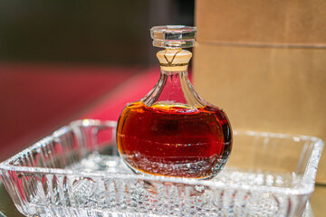 Close-up of a round-bottomed, amber liquid-filled bottle with cork stopper on frosted glass surface...