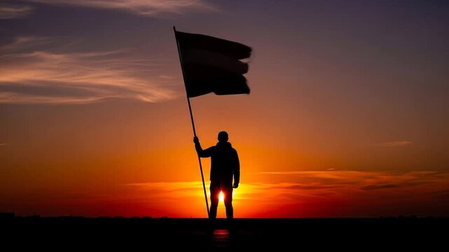 Silhouette of a Person Holding a Flag During a Vibrant Sunset