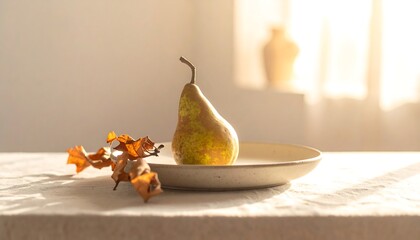 A single pear on a plate, alongside autumn leaves, bathed in sunlight