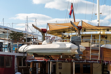 Inflatable RIB tender on yacht davits with outboard
