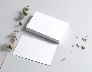 Blank business cards on a gray surface with eucalyptus