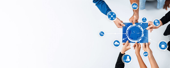 A diverse group of individuals collaborates around a table with a digital graphic interface, showcasing innovative business concepts and strategies for success. Amity