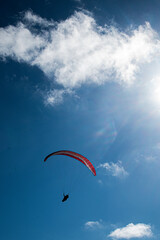 Paragliding adventure under a blue sky with fluffy clouds on a sunny day
