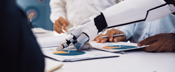 A robotic arm collaborates with business professionals during a meeting, focusing on data analysis...
