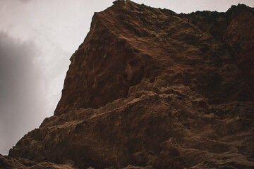 Grand rock formation under a cloudy sky showcases nature's raw beauty in a remote landscape