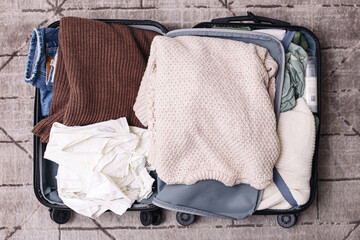 Packed travel suitcase. Clothes inside luggage for journey. Preparation for vacation trip. Baggage...