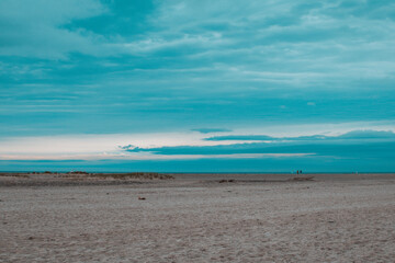 Calm beach landscape at dusk with soft waves and tranquil skies in a serene coastal area