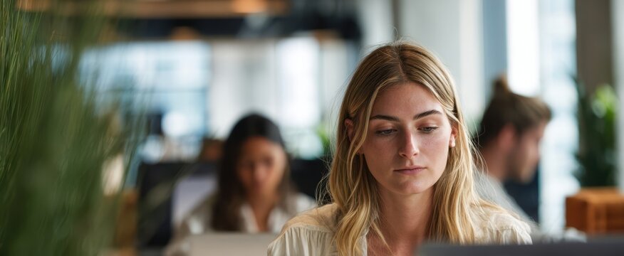 The Woman Working on a Laptop in a Modern Open Plan Office, Focused - Powered by Adobe