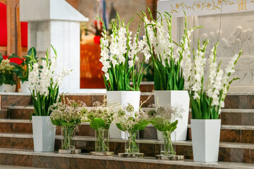 Elegant white wedding flower arrangement at church altar with hydrangeas and greenery