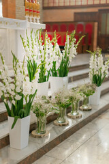Elegant white wedding flower arrangement at church altar with hydrangeas and greenery