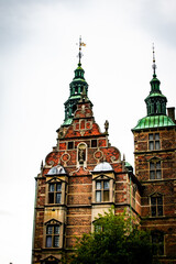 Detailed architecture of a historic Danish castle under a cloudy sky in Denmark