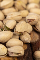 unpeeled pistachio nuts fried in salt, scattered salted pistachios after roasting with cracked shells, close up