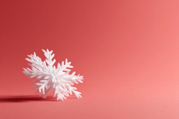 Fototapeta premium Delicate snowflake rests against soft coral background, highligh