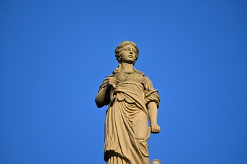 Obraz premium Sculpture of an ancient woman against the blue sky 