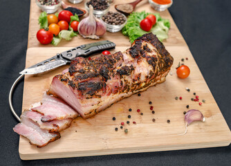 Cropped bacon with knife on wooden cutting board. Spices and vegetables in defocused view. Protein