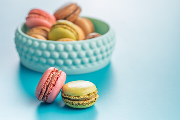 Different flavors of macarons. Colourful macaroons on blue background.