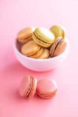 Different flavors of macarons. Colourful macaroons on pink background.