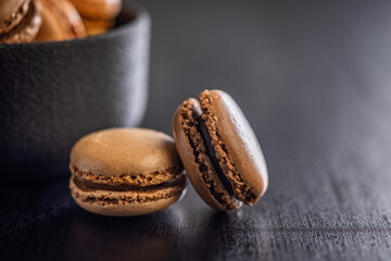 Different flavors of macarons. Colourful macaroons on black table.