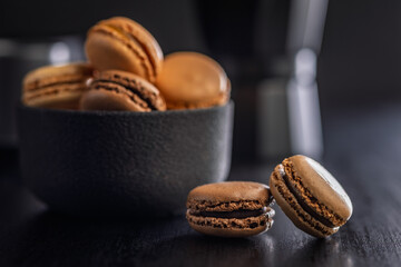Different flavors of macarons. Colourful macaroons on black table.