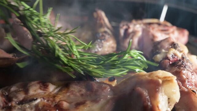 grilling lamb chops brushing oil  with rosemary on hot smoking BBQ picnic. Charcoal-Roasted Succulent Barbecue