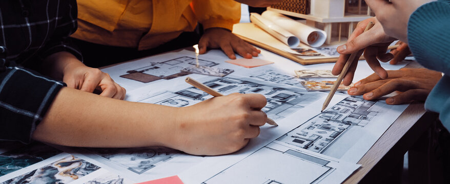 A diverse team engages in a collaborative design session, working together on detailed architectural blueprints and sketches while brainstorming innovative ideas. SACTR