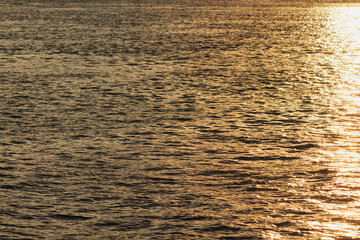 Golden sunset reflecting on tranquil water surface at dusk