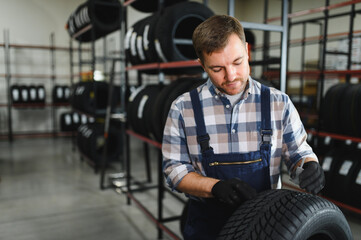 Portrait of a worker in a new car tire shop. Concept of changing tires © Serhii