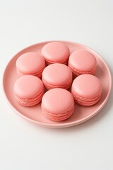 Obraz premium Pink macarons arranged on matching pink plate