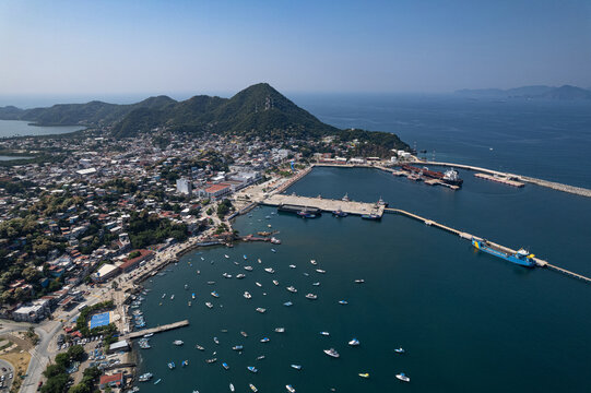 Aerial view of downtown Manzanillo Colima and its bay with motorboats and fishing vessels. Marine landscape with urban architecture and traditional port.