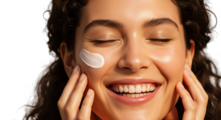 A smiling woman with curly hair has a dollop of cream on her cheek isolated on transparent background