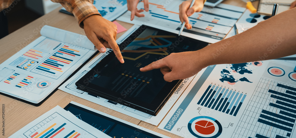 Poster a dynamic group of professionals collaborates around a digital tablet, engaged in data analysis whil