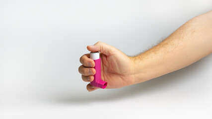 Hands holding asthma inhaler,Bronchodilator  for relief asthma attack on white background. Pharmaceutical products is used to prevent and treat wheezing and shortness of breath caused asthma or COPD.