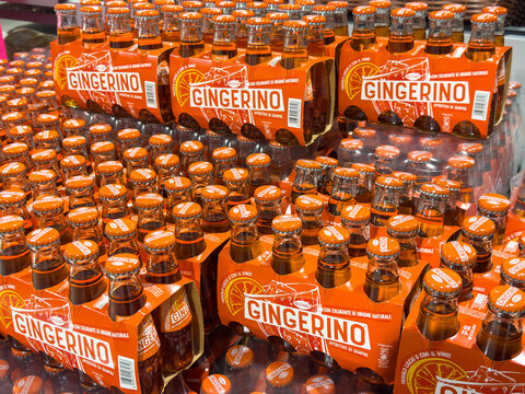 Gemona, Italy - September 24, 2025: Gingerino ginger soda bottles stacked in vibrant orange packaging, showcasing refreshing beverage options for consumers in a retail environment