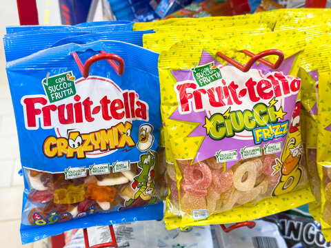 Gemona, Italy - September 24, 2025: Colorful Fruit-tella gummy candy packages on display, showcasing Crazy Mix and Fruzz flavors, vibrant packaging attracting attention in a retail environment
